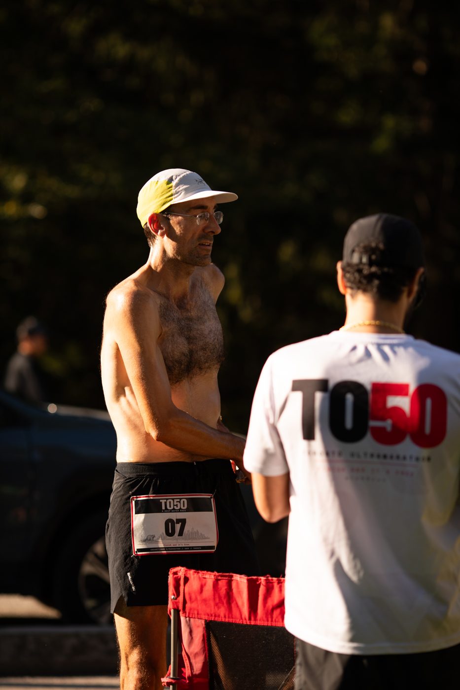 A finisher talking to a volunteer at the TO50 Toronto ultramarathon finish line